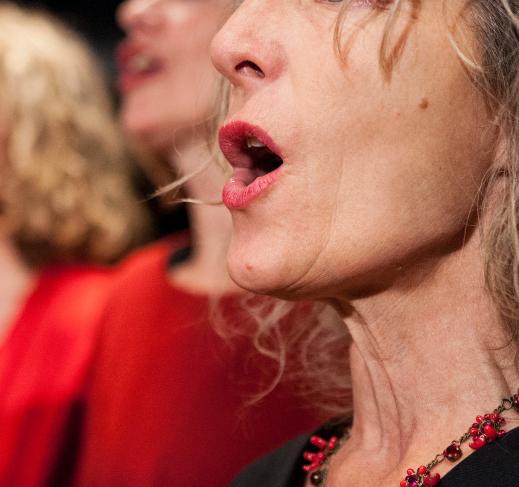 Frau vom Frauenchor bocc'apperta am singen mit geöffnetem Mund